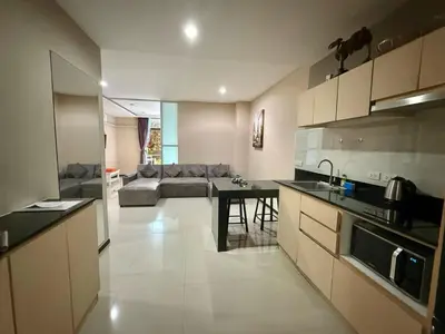 a kitchen and living room with a couch and a table at апартаменты NBC Nai Harn in Rawai Beach