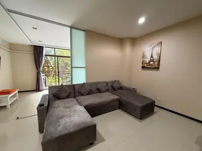 a living room with a couch and a large window at апартаменты NBC Nai Harn in Rawai Beach