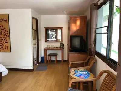 a room with a living room with a tv and a table at Paradise Resort Phi Phi in Phi Phi Don