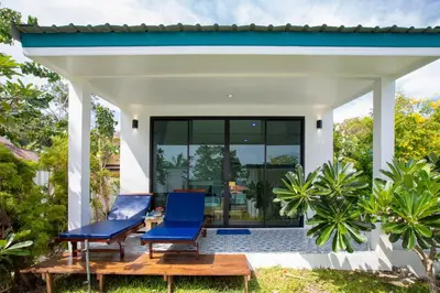 a house with two blue chairs on a patio at Paradise Resort Phi Phi in Phi Phi Don