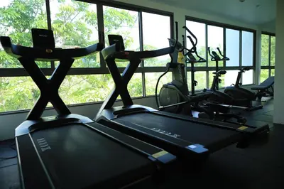 a gym with several cardio bikes in a room with windows at Apartment near the sea Kamala beach 601 in Kamala Beach
