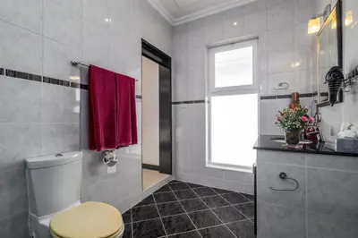 a bathroom with a toilet and a window at Luxurious & Quiet Pool Villa Orchid in Nai Yang Beach