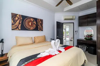 a bedroom with a bed and a painting on the wall at Luxurious & Quiet Pool Villa Orchid in Nai Yang Beach
