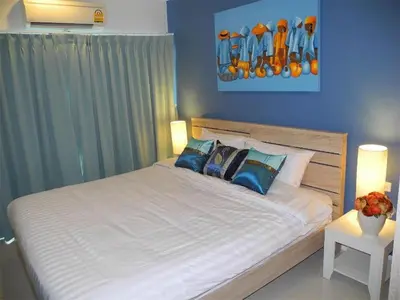 a bedroom with a large white bed with blue walls at 2 Bedrooms Beachfront Apartment in Patong in Patong Beach