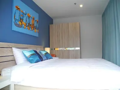 a bedroom with a bed and a blue wall at 2 Bedrooms Beachfront Apartment in Patong in Patong Beach