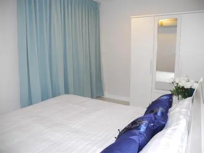 a bedroom with a large bed and a mirror at 2 Bedrooms Beachfront Apartment in Patong in Patong Beach