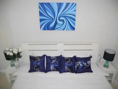 a bedroom with a white bed with blue pillows at 2 Bedrooms Beachfront Apartment in Patong in Patong Beach