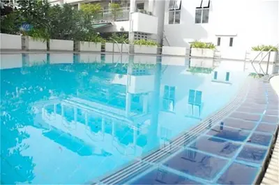 a large swimming pool with blue water in front of a building at 2 Bedrooms Beachfront Apartment in Patong in Patong Beach