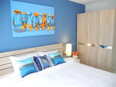 a bedroom with a white bed with blue walls at 2 Bedrooms Beachfront Apartment in Patong in Patong Beach