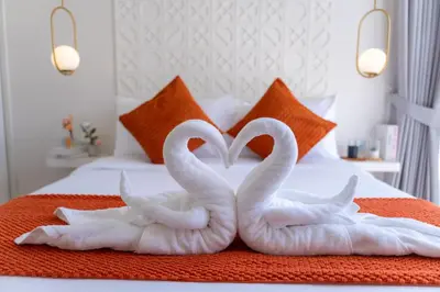two white swans making a heart shape on a bed at Coconus Pool Villa \u963f\u4e3d\u838e \u6cf3\u6c60\u522b\u5885 in Ban Pak Lak