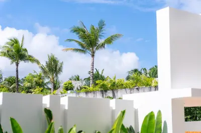 a white fence with palm trees in the background at Coconus Pool Villa \u963f\u4e3d\u838e \u6cf3\u6c60\u522b\u5885 in Ban Pak Lak