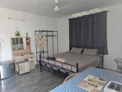 a bedroom with a bed and a tv and a table at Kata Cozy Guest Room in Kata Beach