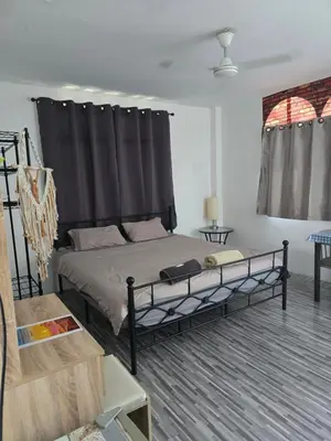 a bedroom with a bed with a black frame at Kata Cozy Guest Room in Kata Beach