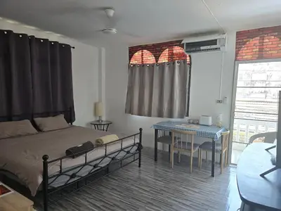 a bedroom with a bed and a table in it at Kata Cozy Guest Room in Kata Beach