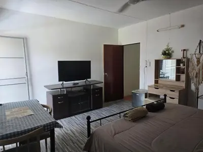 a bedroom with a bed and a flat screen tv at Kata Cozy Guest Room in Kata Beach