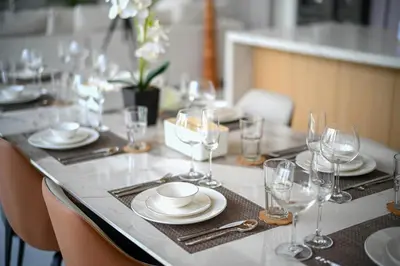 a table with glasses and plates and napkins on it at Asherah Villa By Asherah Team in Ban Phru Champa