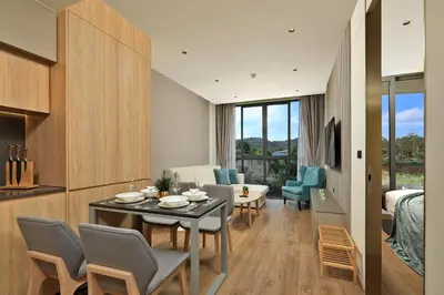 a dining room and living room with a table and chairs at New 1 bdr Apartment near Layan beach C610 in Ko Kala