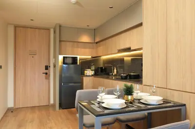 a kitchen with a table with bowls and wine glasses at New 1 bdr Apartment near Layan beach C610 in Ko Kala