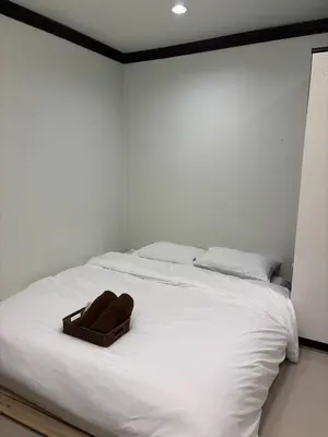 a white bed with a brown towel on it at Spacious and cozy Thai House in Ban Bang Khu