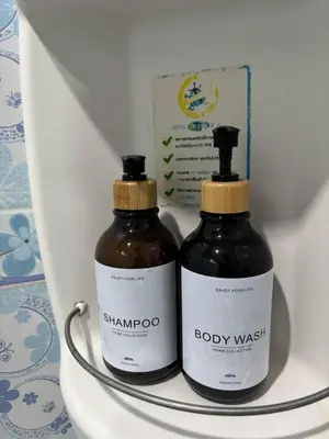 two bottles of shampoo and a box on a shelf at Spacious and cozy Thai House in Ban Bang Khu