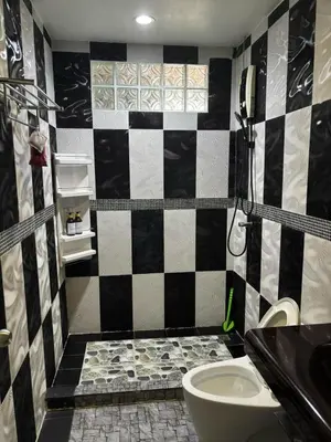a bathroom with a black and white checkered wall at Spacious and cozy Thai House in Ban Bang Khu
