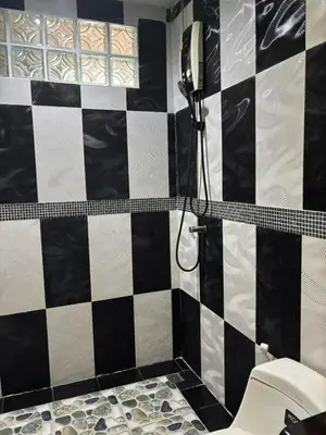 a bathroom with a black and white checkered wall at Spacious and cozy Thai House in Ban Bang Khu