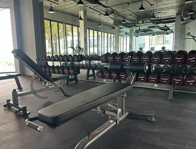 a gym with a row of dumbbells and a treadmill at Bellevue lagoon 20 units in Laguna Phuket