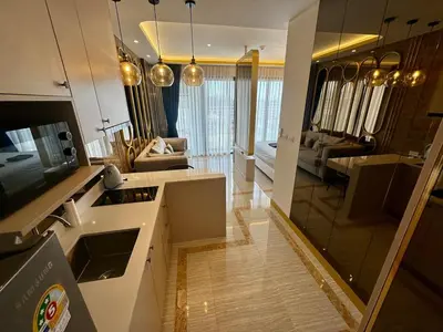 a kitchen and living room with a large mirror at Bellevue lagoon 20 units in Laguna Phuket