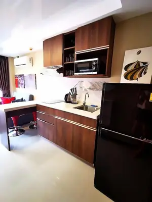a kitchen with a black refrigerator and a sink at 1 bedroom Naiharn Beach Condo in Rawai Beach