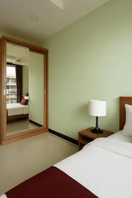 a hotel room with a bed and a mirror at 1 bedroom Naiharn Beach Condo in Rawai Beach