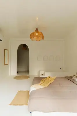 a white bedroom with a bed and a chandelier at The hidden home in Patong Beach