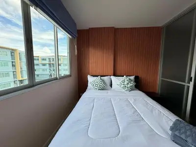 a bed in a room with a large window at Dcondo kathu phuket in Kathu