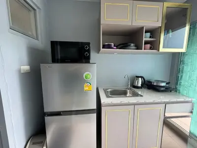 a small kitchen with a refrigerator and a sink at Dcondo kathu phuket in Kathu