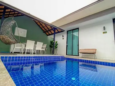 a swimming pool in a house with a table and chairs at The COZY NATURE pool villas phuket in Koh Lone