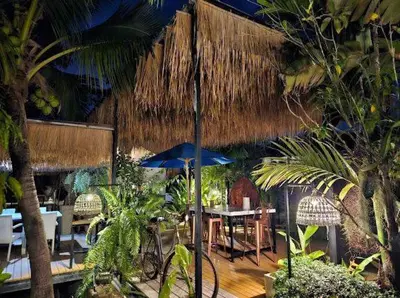 a restaurant with a table and chairs and an umbrella at The COZY NATURE pool villas phuket in Koh Lone