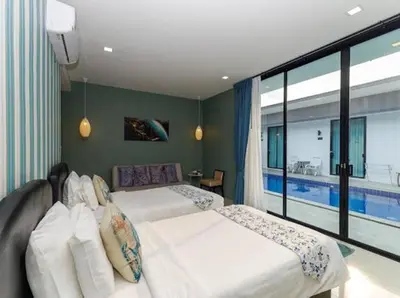 a bedroom with two beds and a large window at The COZY NATURE pool villas phuket in Koh Lone