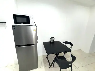 a small table with a refrigerator and a table with chairs at Patong Canal Villa 110 in Patong Beach