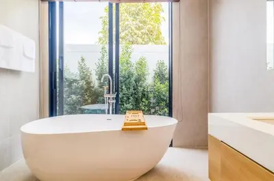 a bath tub in a bathroom with a large window at Le Da Villas 5BR Private Pool Villa, Bangtao Beach Phuket in Laguna Phuket