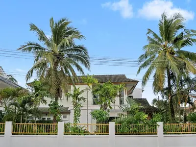 a white fence in front of a house with palm trees at 3 Bedrooms - 2 floor with garden in Prime Location in Thalang
