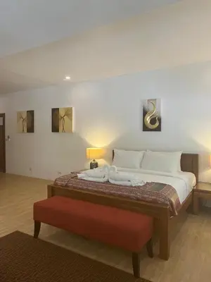 a bedroom with a large bed with a red bench at Private beachfront Villa Natai with 5 bedrooms in Ban Na Tai
