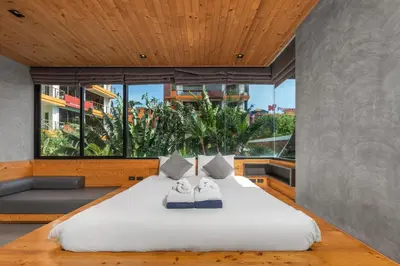 a bedroom with a large bed with two towels on it at Relife Apartments by Tropiclook - Fast WiFi , Pool and Gym in Phuket Town