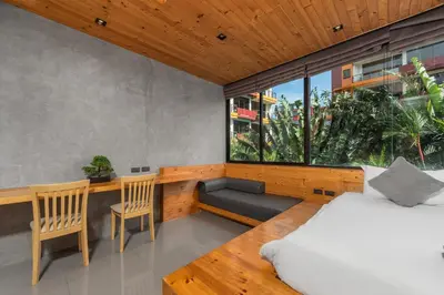 a bedroom with a bed and a bench and a window at Relife Apartments by Tropiclook - Fast WiFi , Pool and Gym in Phuket Town