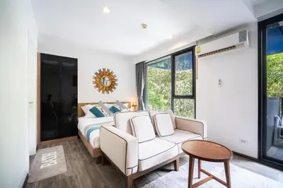 a bedroom with a bed and a couch and a table at \u82ad\u4e1c\u6d77\u6ee9THEDECK166\u7cbe\u88c5\u516c\u5bd3\u9152\u5427\u8857Jungceylon10\u5206\u949f in Patong Beach