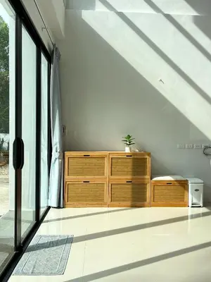 a bedroom with a wooden dresser and large windows at The Passion House in Ban Na Nai