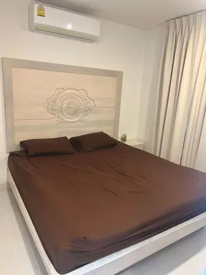 a bedroom with a large bed with a brown comforter at Sea view Karon Butterfly 2 bdr in Karon Beach