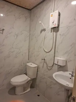 a bathroom with a toilet and a sink at ฟาดิลบังกะโล Fadel bungalow in Ko Nui