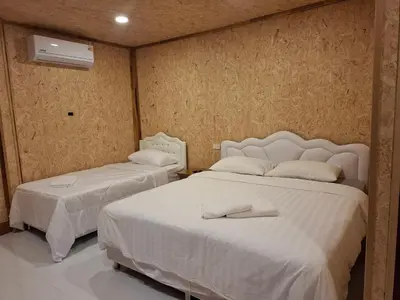 a bedroom with two beds with white sheets at ฟาดิลบังกะโล Fadel bungalow in Ko Nui