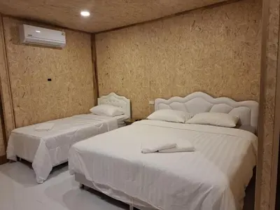 a bedroom with two beds with white sheets at ฟาดิลบังกะโล Fadel bungalow in Ko Nui