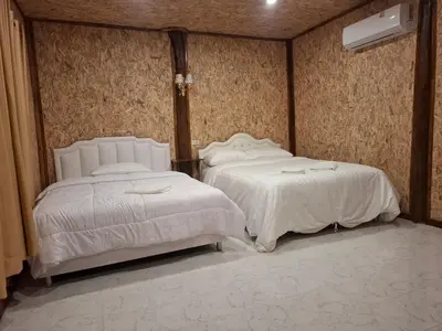 two beds sitting next to each other in a bedroom at ฟาดิลบังกะโล Fadel bungalow in Ko Nui