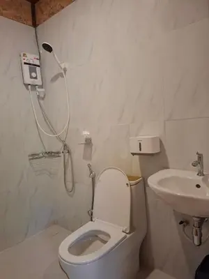 a bathroom with a shower and a toilet and a sink at ฟาดิลบังกะโล Fadel bungalow in Ko Nui